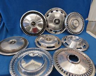 Lot 36. Eight old hubcaps