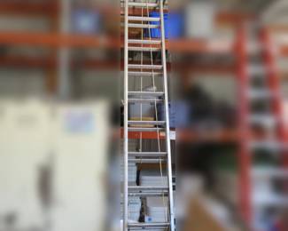 Lot 269. Montgomery Ward 28' extension ladder. The orange ladder and other items seen in the photo are not included.