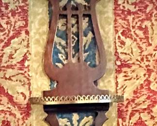 One of two carved wood and brass shelves