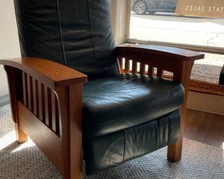 Cherry Arts & Crafts Recliner Upholstered in Hunter Green Leather. Leather has Patina Consistent with Age. Measures 34.4" W x 34" D x 41" H. When Open, Depth is 56" W.
