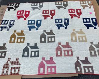 VINTAGE QUILT 80 X 68". HOUSES HAVE EMBROIDERED STITCHING REPRESENTING LOG HOUSE, BRICK HOUSE, COBBLESTONES. STAINS ON REVERSE FROM BLEED OF COLORED FABRIC. SHAKER HOUSE BLOCK PATTERN