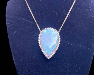 Opal pendant is convertible to pin or enhancer.  The opal is a large pear shape measuring 38 x 22 and weighs approximately 14 carats.  Has little play 

of color.  The stone exhibits crazing and is surrounded by 46 2mm round brilliant diamonds with a total weight of approximately 1.45 carats.  They are eye clean and near colorless with good proportions.  Written replacement by Korona Jewelry is $4000.