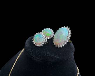 Opal ring-opal measures 25x19 and weighs approximately 22 carats.  It has fair play of color, mostly greenish.  22 round brilliant diamonds measuring 3.5mm with a total weight of 3.5 to 3.75 carats surround the opal.  All are eye clean, near colorless and fair proportions.  The ring is 14k gold with a finger fit attachment.  Sizes from 6.5 to 5.5.  Written replacement appraisal by Korona Jewelry is $11,000-$12,000 