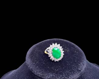 Oval Jadeite ring with a double cluster of diamonds.  The Jade has a nice green slightly mottled color.  It measures 14x10mm.  The inner cluster has 18 round brilliant diamonds measuring approximately 2.5mm.  The outer row also has 18 round brilliant diamonds measuring 2mm.  They are all eye clean and near colorless with good proportions.  The total diamond weight is approximately 2 carats.  The ring is 14 karat white gold with a finger-fit shank that opens to a size 7.5 and closes to a 6.5.  The written replacement value by Korona Jewelry is $3500.