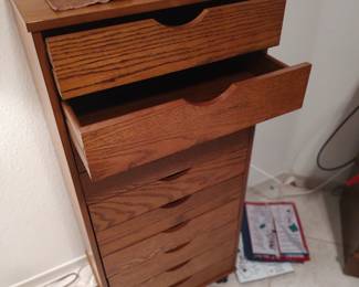 very nice wooden craft cabinet on rollers.  10 drawers, 41" tall