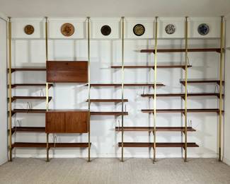 MID-CENTURY WALL UNIT | Seven posts (with 10" extenders) one cabinet with sliding doors (30 x 15 x h. 16), a fall-front cabinet (30 x 12 x h. 16h, (5pc) 30 x 10 in. shelves (3pc) 32 x 8 in. shelves(6pc) 60 x 8 in. shelves (2pc) 60 x 10 in. shelves plus matching bent metal bookend clips - l. 160 x w. 17 x h. 108 in. (approximately, as shown)