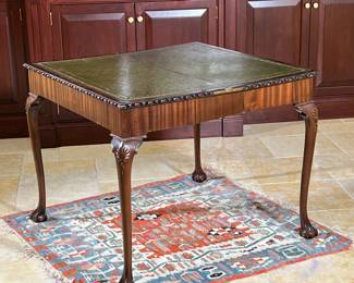 ANTIQUE CARVED GAMES TABLE | English, 18th/19th-century oblong egg and dart carved edge, inset leather top, double-hinged collapsing sides raised on four cabriole legs with shell carvings at the knee terminating in ball and claw feet - l. 36 x w. 36 x h. 29.5 in. (opened)