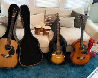 Several electric and acoustic guitars and a set of bongos
