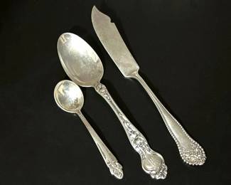 Sterling silver pieces, a baby spoon by Wolfenden Silver Co of North Attleboro, Mass.,  Teaspoon 'Violet' 1904 pattern by Wallace & Sons, and a butter knife 'Lancaster' 1897 by Gorham 