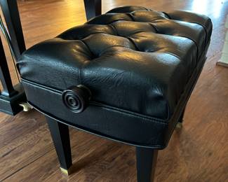Includes a tufted black leather piano bench with under seat storage with a high polish black frame and legs.