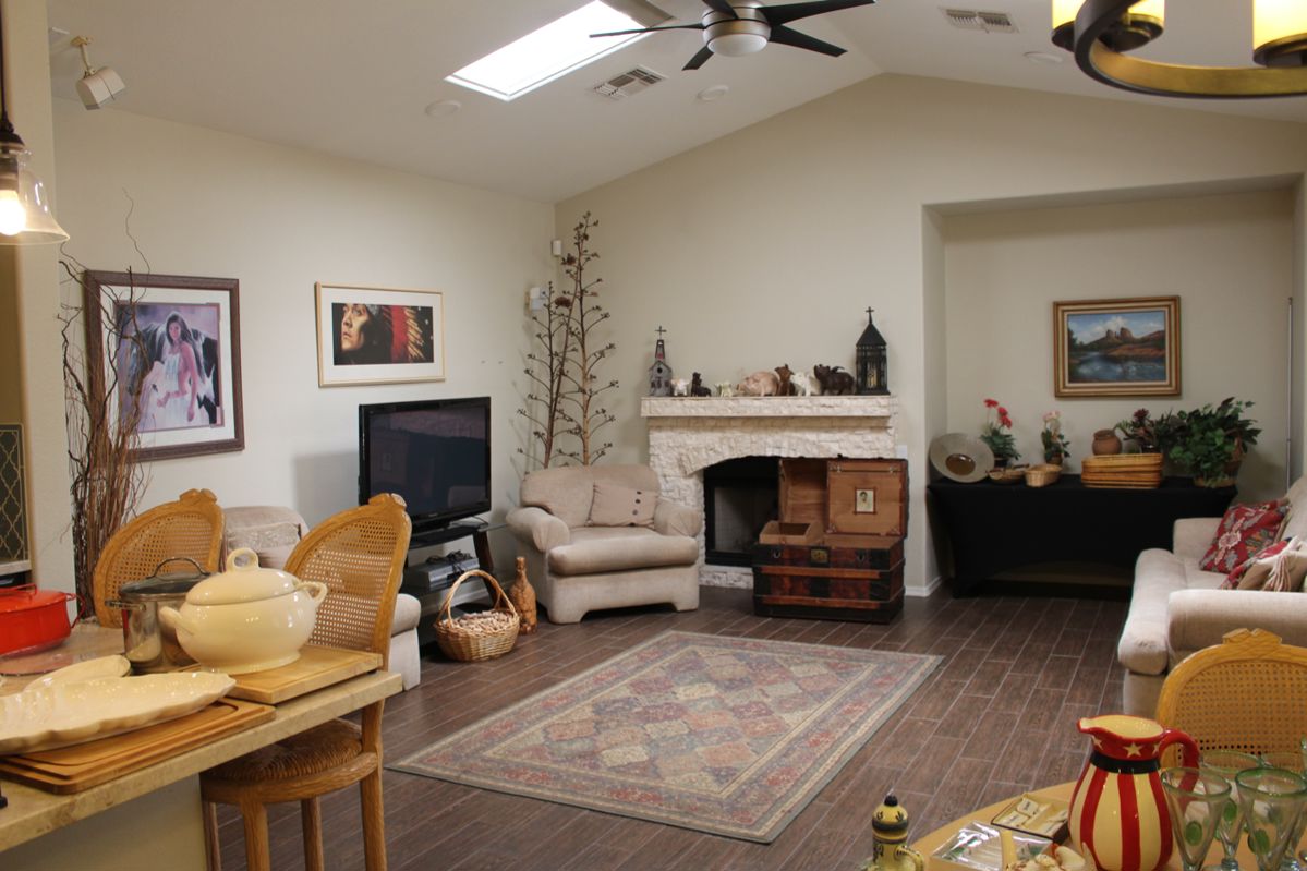 Family room view with dried Agave flower sticks, art, antique trunk and piggies on the mantel
