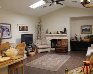 Family room view with dried Agave flower sticks, art, antique trunk and piggies on the mantel