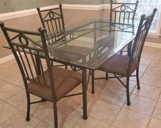 Beautiful powder coated steel dining table with beveled edge tempered glass top and four matching chairs!  42” x 72”.  $250.  