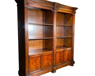 CARVED MAHOGANY DOUBLE BOOKCASE | Large mahogany double bookcase showing detailed carved and fluted pillars, 6 large shelves, burlwood paneled cabinets below with 2 shelves each and large round feet. - l. 86 x w. 20 x h. 90 in