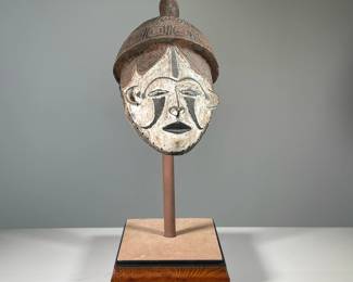 AFRICAN CARVED & PAINTED WOOD MASK | Nigerian 20th century carved wood mask mounted on wood plinth. -  l. 11 x w. 9 x h. 23 in
