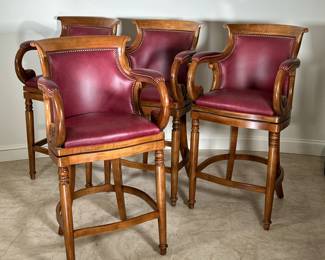 HANCOCK & MOORE JOCKEY CLUB SWIVEL BAR STOOLS | With cavalier oxblood leather and medium oak finish, brass tacks, and scrolls carvings. -Original Retail Price for all 4: $5,300. -  l. 25 x w. 24 x h. 44 in