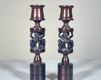 (2PC) PAIR CARVED WOOD AFRICAN CANDLESTICKS | Carved African candlesticks showing 2 men holding up the top of each candlestick. - h. 9.5 x dia. 2 ft