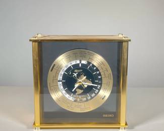 SEIKO GLOBAL TIME ZONE MANTLE CLOCK | Seiko mantle clock showing global time zones and major cities around the border of the clock with an inner ring showing their equivalent time difference to the set location/time as well as a small airplane on the second hand that circle an image of the globe in the center. - l. 8.5 x w. 3 x h. 8.5 in