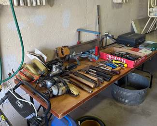 Tools are split between the garage and the basement! BOTH have a table full of tools. 
