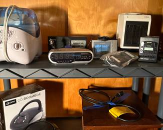 An entire room full of electronics big and small! ALL work! Many in their original boxes! Small handheld radios, Vintage Sony Walkman, CD players, Amazon Kindle, Heaters and MORE! (Note bottom shelf is FILLED with cords of every shape and size!)