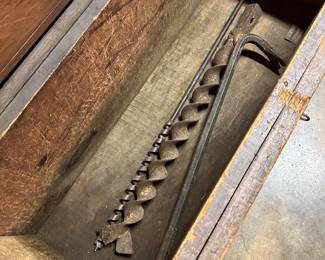 These massive drill bits were in the huge wooden tool box. 