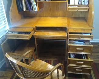 Beautiful solid oak rolltop computer desk and matching wicker office chair.  No tools needed to disassemble into five components.  When assembled it is 63 in. high and the desktop is 62 in. wide, 32 in. deep.  Features a pull-out overhead LED light, two slide-out writing surfaces, hidden keyboard drawer, locking drawer/printer cabinet for a total of seven drawers and eight large cubbies.
