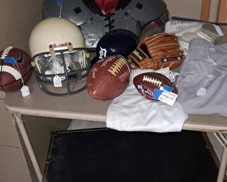 Riddell Football Helmet; Footballs; Black Trunk; Wilson Baseball Mitt; Detroit Baseball Plastic Helmet; Football Uniform Pants, Etc.