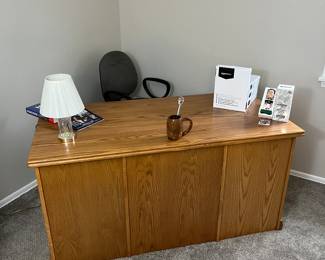 Amish made oak desk, four reams of copy paper, desktop lamp and McDonald’s Drew Bledsoe bobble head.