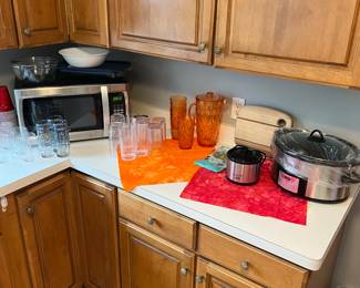 Microwave oven, large crockpot, small crockpot, cutting board and plastic sets of cups and pitcher.