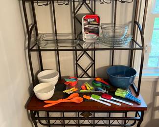 Bakers rack with baking pans, mixing bowls and baking utensils.