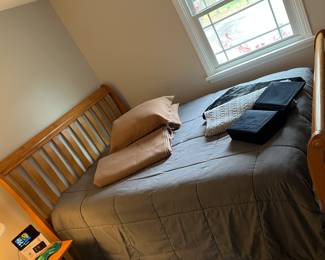 Full size mission style bed with full-size sets of sheets and pillowcases.