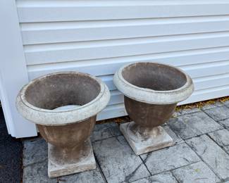 A pair of concrete pedestal planters.
