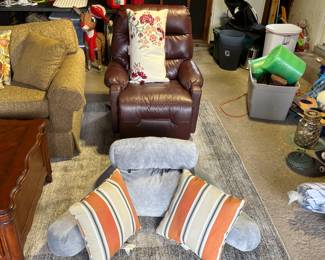 One of two matching leather swivel recliners with pillow and floor pillow seat. 