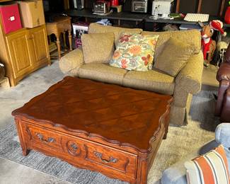 Loveseat pull out sofa bed w/ pillows and coffee table  with storage below.