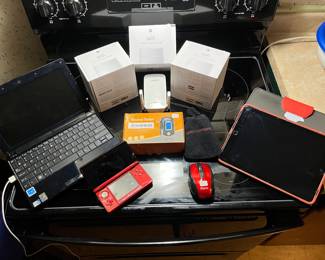 Three home Wi-Fi systems by Google, wireless mouse, handheld alcohol tester, Linksys router, Apple Eee tablet and Targus tablet.
