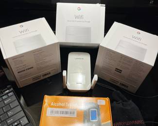 Three home Wi-Fi systems by google, alcohol tester and Linksys router.