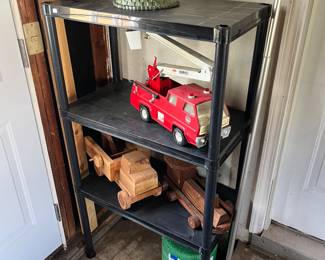 Vintage metal Tonka fire truck with Hook and ladder, homemade wood trucks and metal shelving unit.