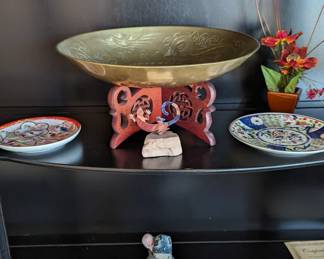 Decorative tin bowl on wooden perch, decorative plates and made in Africa carved mother and child figurine.