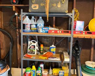 Vintage storage trunks, car care products, lawn care products and  metal shelving unit.