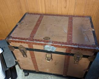 Vintage steamer trunk on wheels.