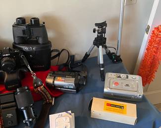 Binoculars, vintage Kodak remote extension cord, tripod,  Sony video recorder, Kodak easy share printing dock and apple ear buds.