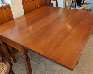 Antique cherry gate leg drop leaf table with one leaf up.