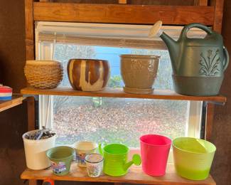 Tin and ceramic planters and tin and plastic watering cans.