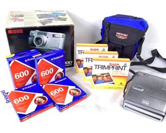GRLE912 Vintage Polaroid Film Cameras Ricoh ROC-5300 digital camera in original box with manuals, VHS, and cords sealed in original packaging - untested. &nbsp;Polaroid one camera, manuals, and camera bag - untested. &nbsp;4 unopened packages Polaroid 600 instant film - expired. &nbsp;3 unopened boxes Kodak Trimprint Instant Color Film - expired.
