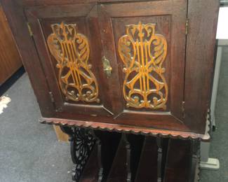 FULL VIEW OF AN AMERICAN CARVED MUSIC CABINET FROM THE LAWRENCE FISHER LENOX AVENUE MANSION DETROIT - FROM THE MUSIC ROOM - ORNATE SCROLL CARVINGS, SIDE STORAGE BELOW, FOR BOOKS & RECORDS, ORIGINAL OLD DARK FINISH.