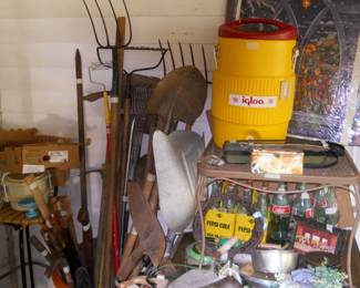 Lots old bottles and yard tools, small patio table