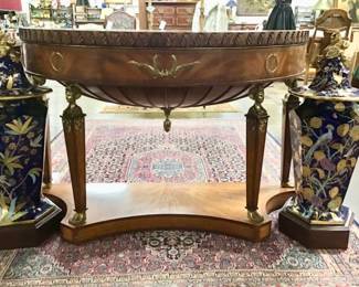 Large Maitland-Smith empire style, inlaid console supported by brass female figures. Inlaid starburst tops the desk. Brass Laurel leaf ormolu accents. Carved acanthus leaf frieze along the top edge.