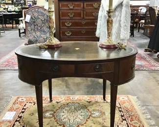 Vintage flame mahogany tooled leather top writing desk by Baker furniture. Single drawer flanked by two fitted letter compartments on either side. Display shelf on cabinet front.