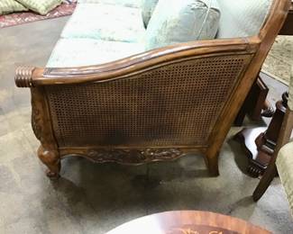 Masterfully, crafted and regally designed SCHNADIG sofa. Curved top with carved wood design on front and back, canned sides, and lovely designer upholstery. 