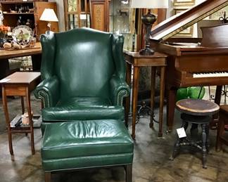 An Ethan Allen leather wing back chair and ottoman. Beautiful Chippendale style frame with nail head trim green leather.